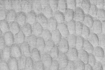 Textured white wooden surface with carved oval patterns and visible wood grain. Abstract texture...