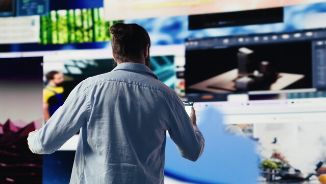 Young happy adult focused on online connection and scrolling on social pages, texting his friends and creating quality content for global reach. Trend setter guy on web design. Camera A.