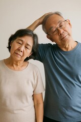 Fototapeta premium Elderly Asian couple doing simple neck stretching exercise together.
