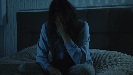 A young woman sits on her bed at night, overwhelmed and unfocused. Her foggy mind and emotional exhaustion reflect insomnia, inner struggle, and mental disorientation. 