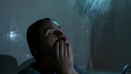 A young woman sits under running shower water at night, overwhelmed and emotionally drained. Dark, cold tones and dramatic lighting reflect sadness, stress, and mental struggle. 