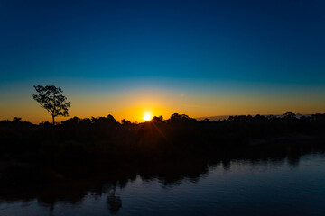 Obraz premium Sunshine Morning Silhouette of a Calm River Landscape with Mountains in Southern Laos