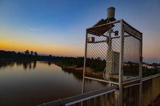 Sunshine Morning View of a Bridge Crossing the Small Mekong River with Flood Warning System Equipment in Southern Laos