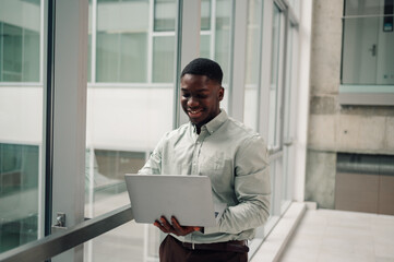 Fototapeta premium Black businessman working on laptop in modern office