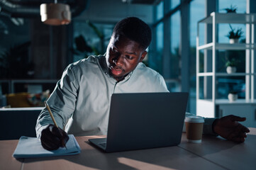 Focused man working late hours in office