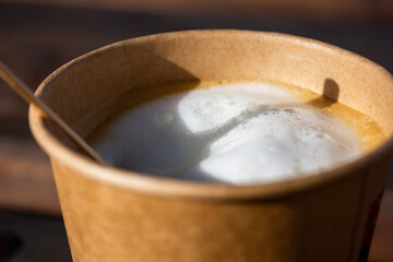 Coffee Cappuccino hot and creamy white served in a cup of brown paper