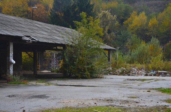 Abandoned industrial building and warehouse with forest in background. Captured in Travnik,Bosnia and Herzegovina on october 2025.