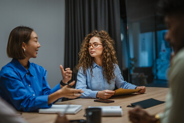 Businesswomen discussing project during corporate team meeting