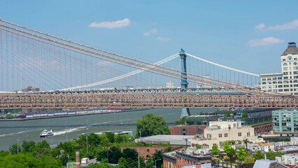 Brooklyn Bridge seen from park perspective with waterfront and cityscape in New York City