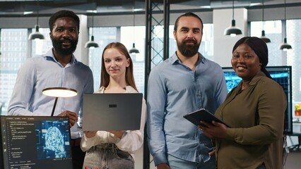 Team of programmers in office automating repetitive tasks using AI scripts on devices. Teamworking...