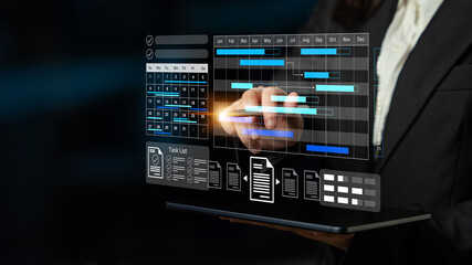 A businessman engages with advanced project management software on a transparent screen, illustrating workflow optimization and digital transformation in a modern office. Gantry
