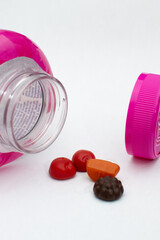 Women&rsquo;s Multivitamins with Pink Bottle on White Background. Close-Up of Women&rsquo;s Multivitamins and Pink Bottle