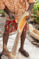 Artisan carving wooden bowl by hand, shaping traditional craft outdoors