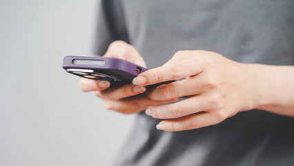 Close-up of both hands holding a smartphone with focus on fingers and device, reflecting modern communication, technology, and digital lifestyle.