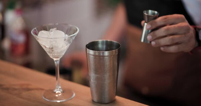 Bartender Pours Liquid From a Jigger Into a Cocktail Shaker at the Bar