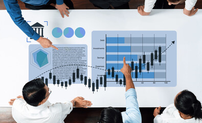 A diverse business team collaborates over a digital table, analyzing financial growth data with graphs and charts. Focus on teamwork and strategic insights. Gantry