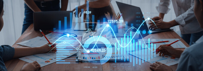A dynamic business meeting featuring team members analyzing financial data with digital graphs and charts overlayed, enhancing collaboration and decision-making. Scalp