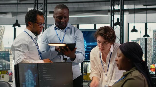Engineering team in office using AI to optimize company systems performance. Coworkers in startup office use artificial intelligence technology to automate tasks, camera B