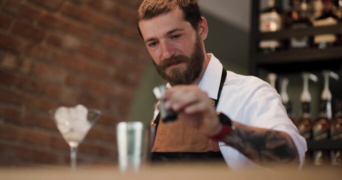 Bartender Pours Red Syrup into Cocktail Shaker: A Skilled Barman at Work