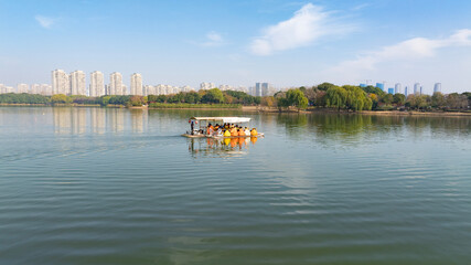 Obraz premium Urban Lake Cruise with Tourists in Life Jackets on Sunny Day
