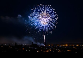 A single, brilliant blue and white firework explodes in a dark night sky over a silhouetted cityscape, capturing the magic and wonder of a New Year's Eve or major festival celebration.

