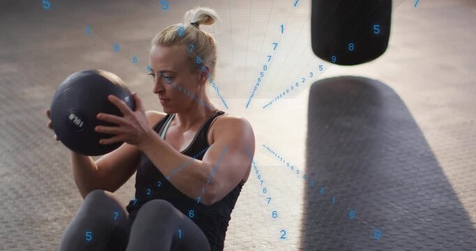 Woman holding med ball, performing twists in gym while blue numeric overlay counting reps for core