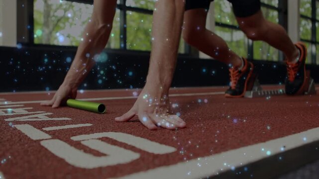 On starter call athlete hands and feet adjusting on lane while grabbing green baton for sprint