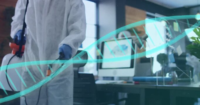 Worker entering left in PPE, spraying desk and plexiglass for office cleaning, teal helix crossing