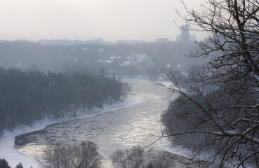 Ice floes float on a frozen river on a sunny winter day. The Neris River near Vilnius, Lithuania. View from the high hill in Verkiu Park.