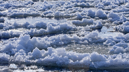 Ice floes float on a frozen river on a sunny winter day. Ice has formed on the Neris River in eastern Lithuania.