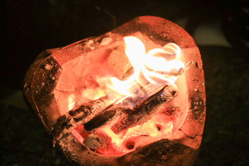 Burning charcoal wood in local stove creating the environment for cooking. Orange hot BBQ fire. 
