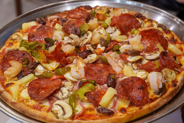 Gourmet Pizza Abundantly Topped with Pepperoni, Succulent Shrimp, Fresh Mushrooms, Olives, and Sweet Pineapple Chunks