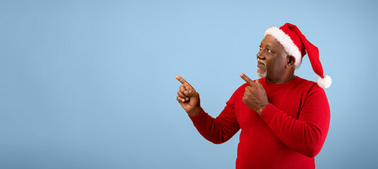 A man wearing a red sweater and a Santa hat stands against a blue background. He points to the left and right as if inviting others to join a festive event during the holiday season.