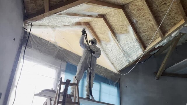Worker applying spray polyurethane foam insulation