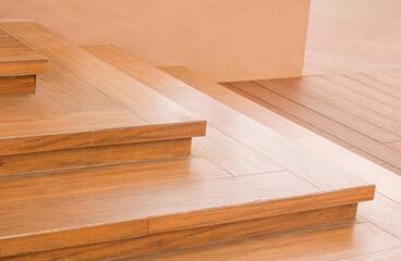 An abstract, closeup view of interior wooden steps or a small staircase, showcasing the clean lines and rich, smooth finish of the light brown hardwood.