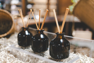 Aromatic Reed Diffusers in Dark Glass Bottles. Minimalist Home Fragrance Display. Home fragrance products, wellness themes, spa concepts, and modern interior styling.