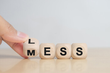 hand hold Less mess words on wooden blocks.