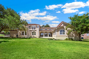 A large house with an expansive lawn is situated in front of it