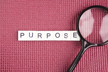Magnifying glass with the word purpose. the concept of purpose. the reason for which something is...