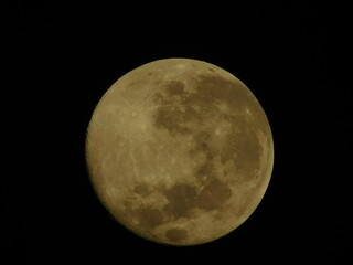 Detailed close-up view of a yellow waxing crescent moon with visible craters against a dark black sky