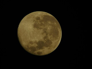 Detailed close-up view of a yellow waxing crescent moon with visible craters against a dark black sky