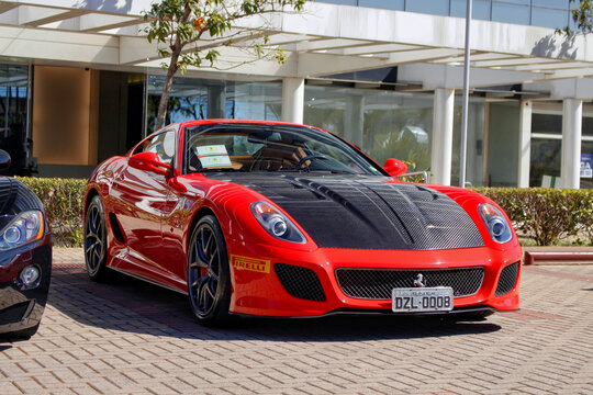 Red Ferrari 599 GTB Fiorano front three quarter view, Supercar parked on paved lot
