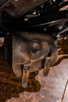 Brown leather motorcycle swingarm bag close up, Custom accessory with embossed skull logo