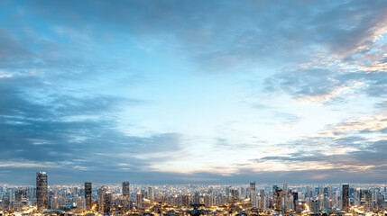 Fototapeta premium Soft navy sky over city skyline at dusk with glowing lights
