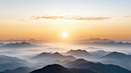 Obraz premium Misty mountain sunrise with layered ridges and soft golden light