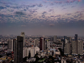 Obraz premium 13 December 2025 colourful sunset with fluffy white pink purple orange and blue skies over the city towers of BKK Bangkok Thai Thailand