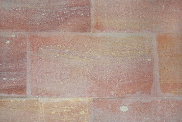 A close-up view of large rectangular sandstone blocks, showing natural horizontal layers and rough, pinkish-yellow texture. © zilvergolf