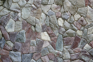 Obraz premium An abstract background texture of an irregular stone wall, featuring various shapes and colors of natural rock fitted together.