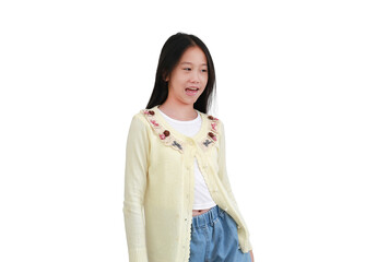 Cheerful young Asian girl in light yellow cardigan and denim jeans standing and looking to the side...