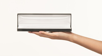 Fototapeta premium A woman's palm holds a open empty black gift box with a white inner lining